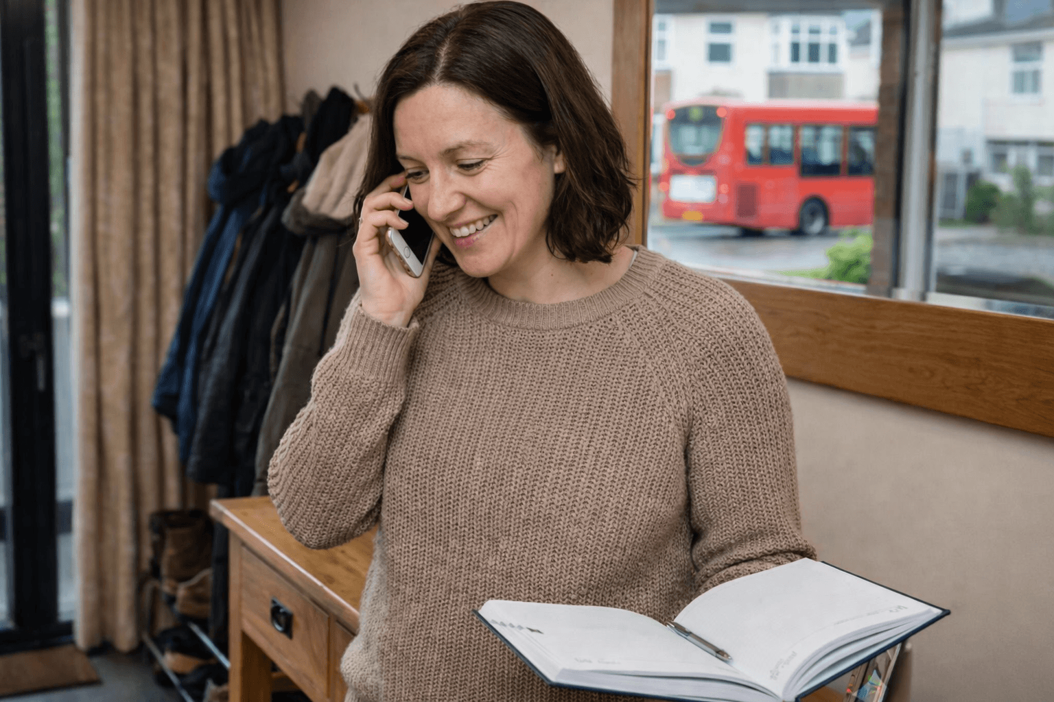 Homeowner speaking on the phone with an advisor while reviewing notes for a home improvement finance application